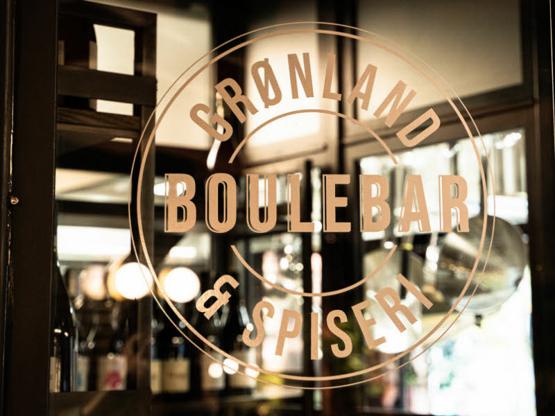 Bildet viser lokalene til Grønland Boulebar som ligger på Grønland i Oslo. Bildet viser logoen til restaurantkonseptet og man ser inn gjennom vinduene.