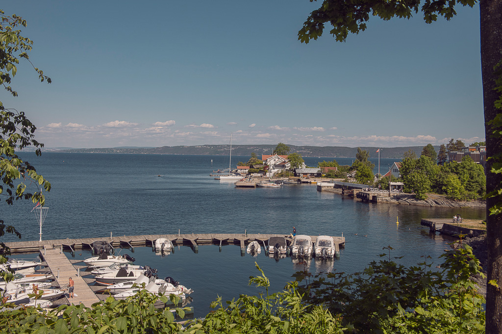 Foto av marinaen i Vollen i Asker sett ovenfra, hvor båter ligger på rekke og rad på det stille vannet.