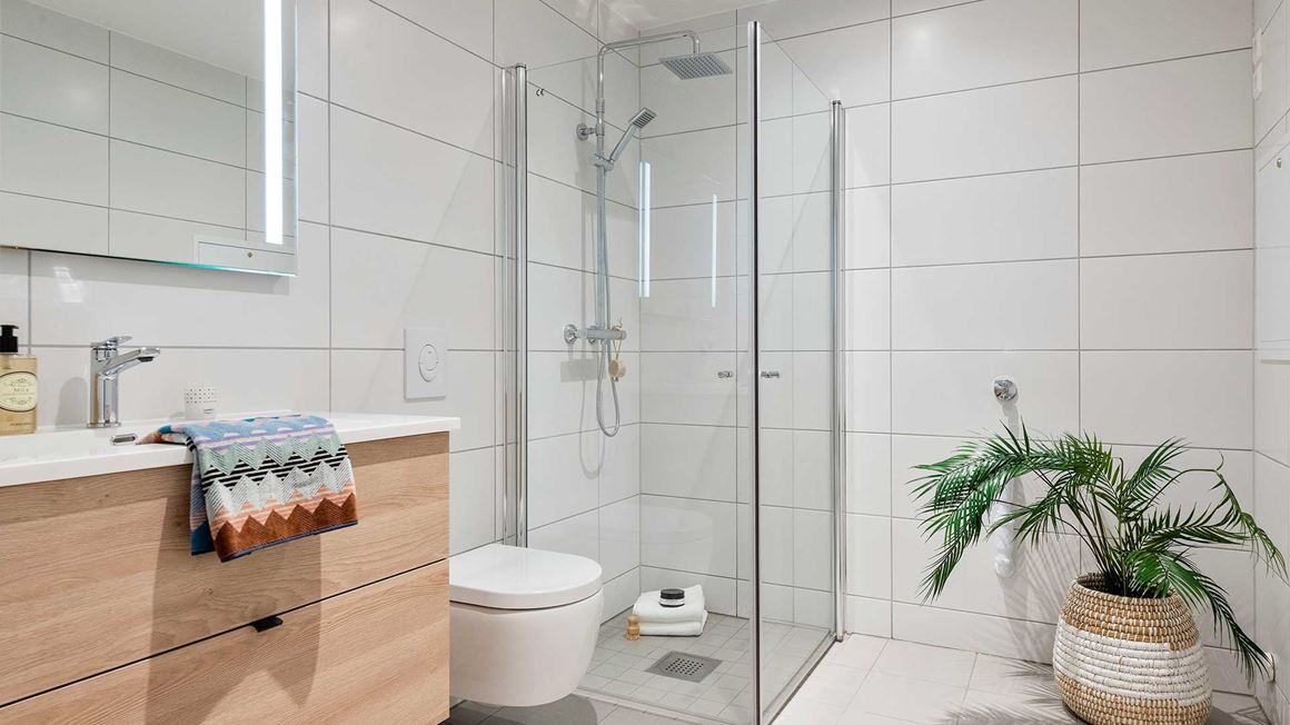 Stor hovedbad med moderne innredning og opplegg til vaskemaskin.