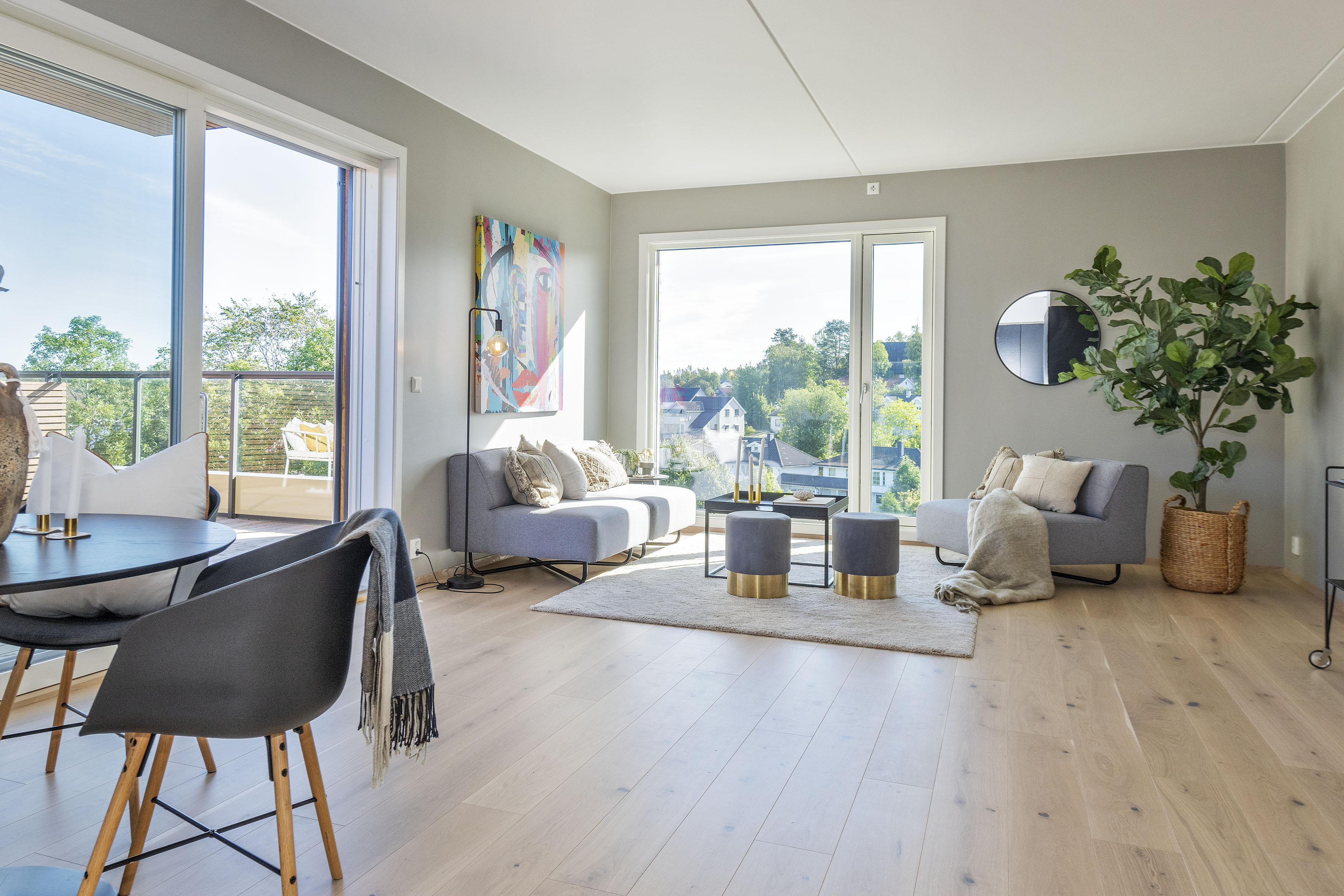 Romslig stue med store vinduer gir mye naturlig lys til leiligheten.