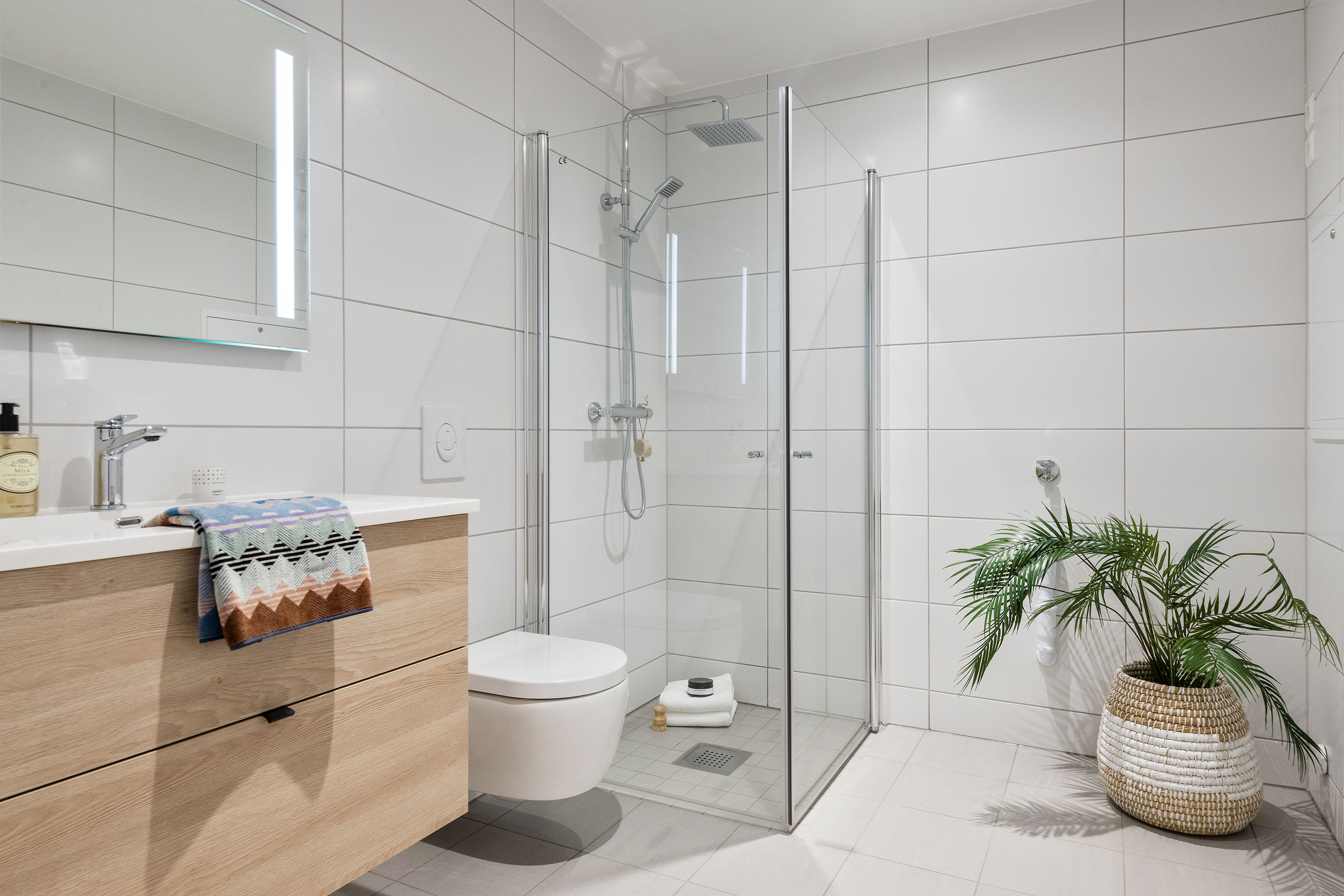 Lekkert bad med varmekabler og opplegg for vaskemaskin.