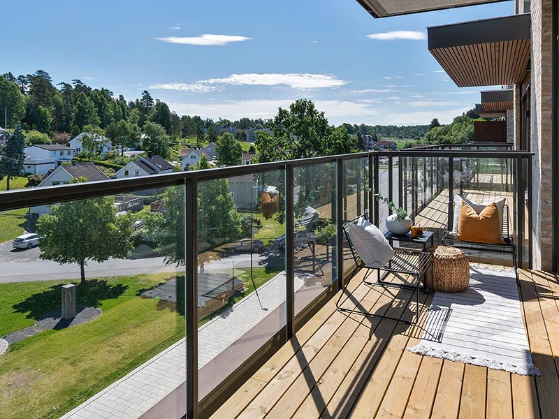 Bilde fra en balkong i boligprosjektet Wessel Park. Leiligheter med balkong mot stille gate i sol.