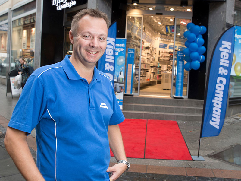 Butikksjefen til Kjell & Company smiler godt foran sin nyåpnede butikk. 