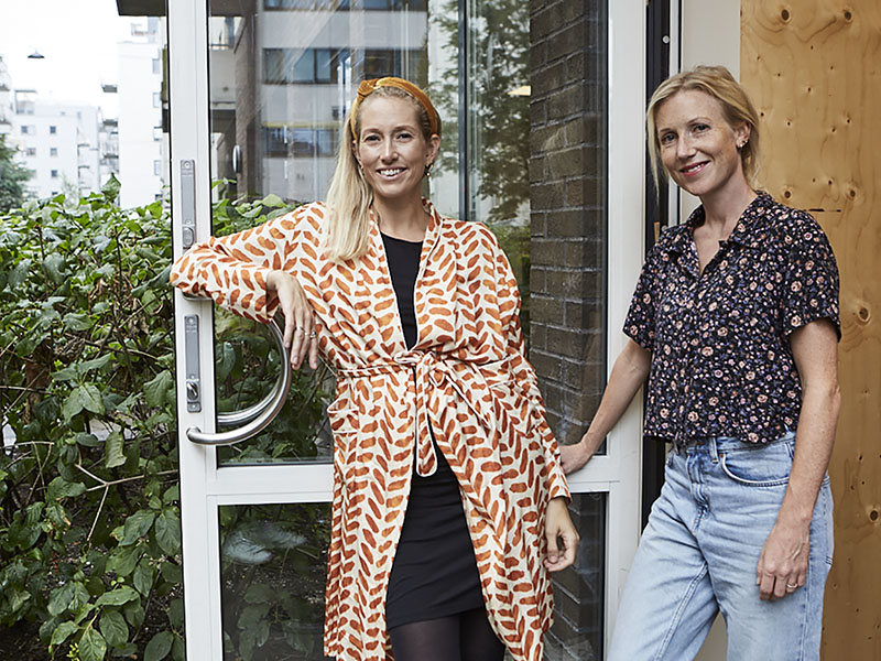 Bildet viser to damer som står i døren til sitt kontorlokale.