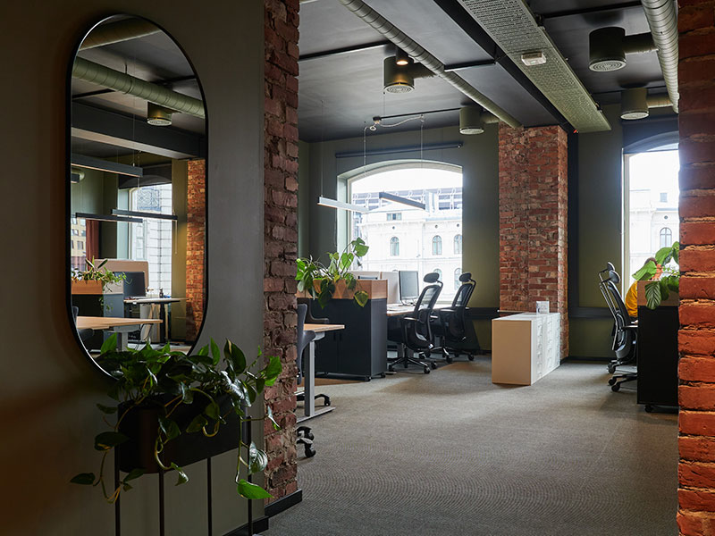 Artikkelbilde som viser rålokalet i Karl Johans gate 2 - murvegger, grønne planter og kontorpulter.