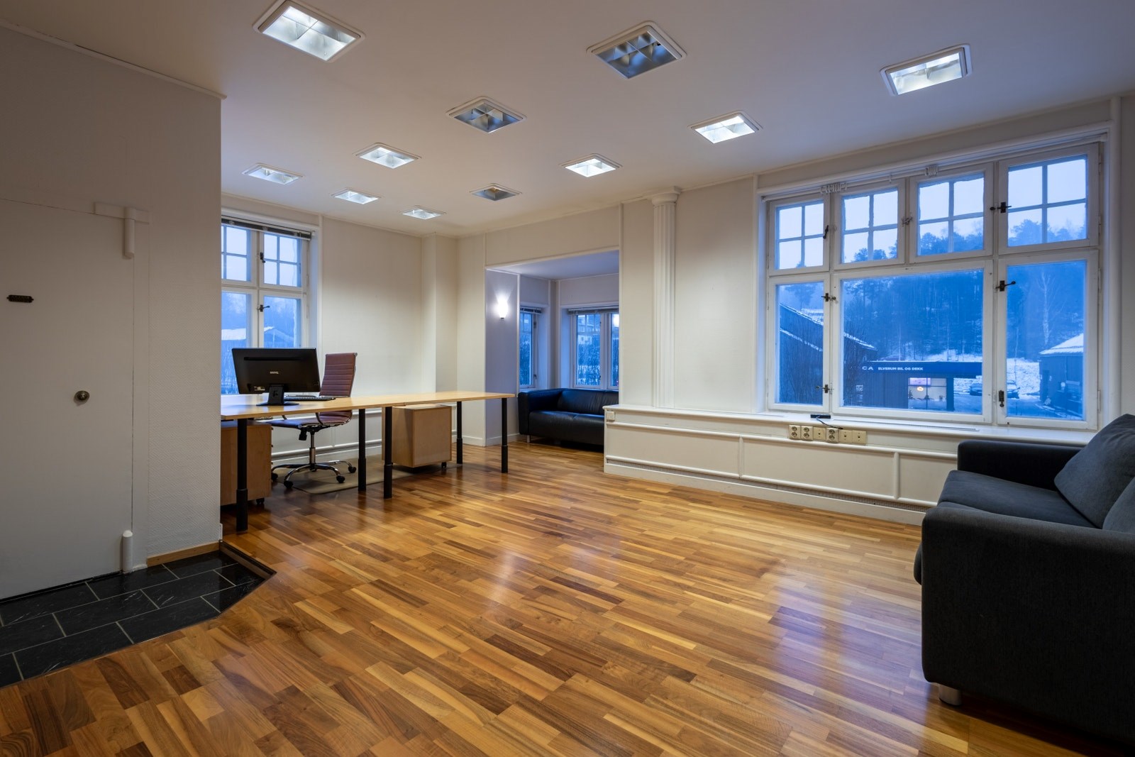 Romslig kontor med plass til både arbeidsstasjoner og sitteområde, egnet for flere arbeidsplasser eller kombinasjonsbruk