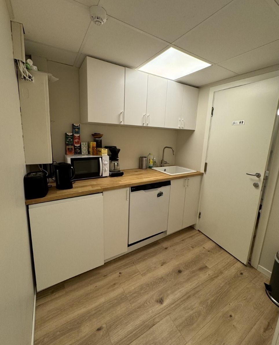 Kjøkken med vask, oppvaskmaskin og kjøl.